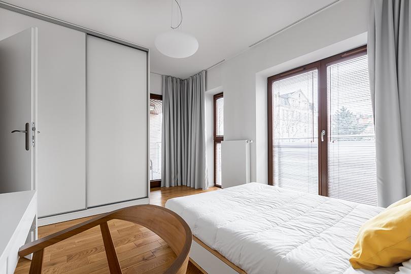 soveværelse med balkon dør og persienner